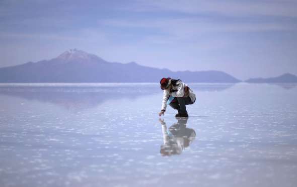 © Zack Seckler Reflective Salt Flats - Salar de Uyuni, Bolivia. Bolivia's Salar de Uyuni is the world's largest salt flat at 4,086 square miles (10,582 square kilometers). Salt flats are vast areas of land covered with salt and other minerals and shine brightly under the sun. Situated near the crest of the Andes at an altitude of 11,995 ft (3,656 m) above sea level, Salar de Uyuni is a major tourist attraction in Bolivia.