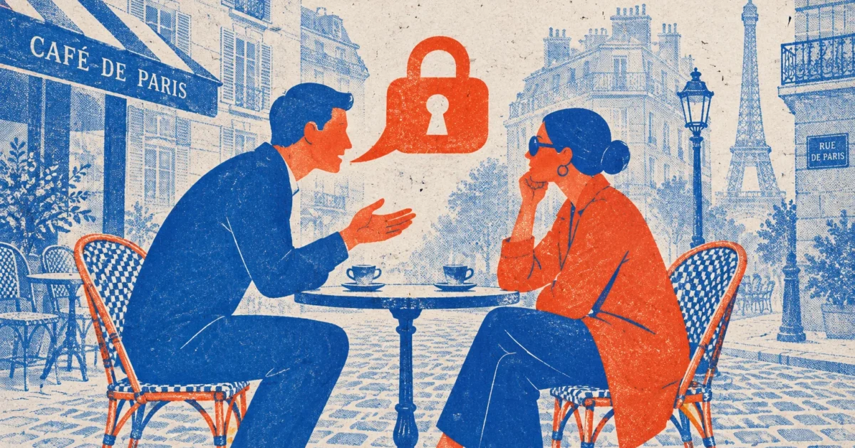 Man and woman seated at a Parisian cafe terrace with an orange speech bubble shaped like a padlock between them.